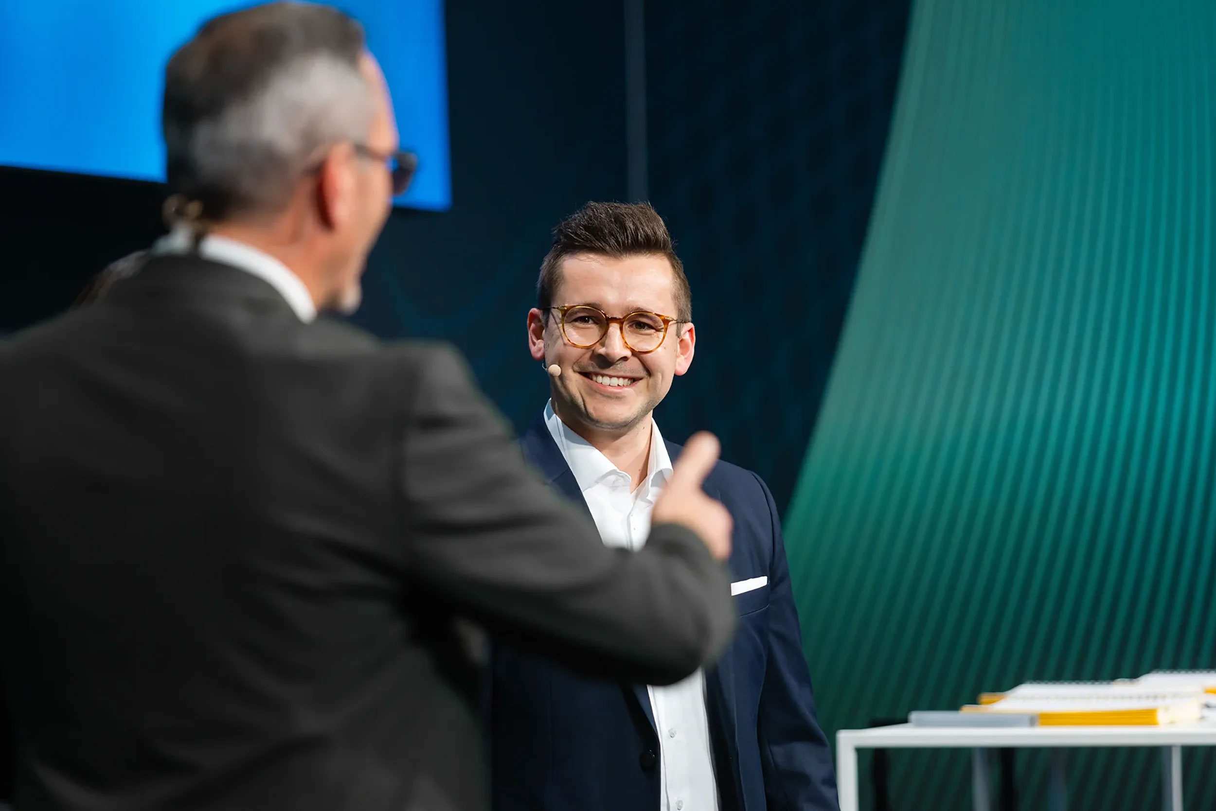 managing director nikolai sauer speaking on stage of big event
